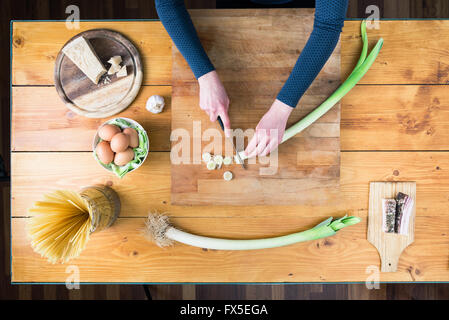 La préparation des pâtes carbonara's. Les mains des femmes préparer le poireau. Banque D'Images