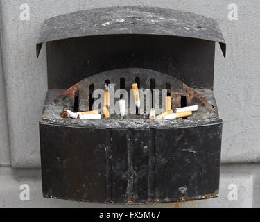 Thrashed cigarettes dans un cendrier public sale Banque D'Images