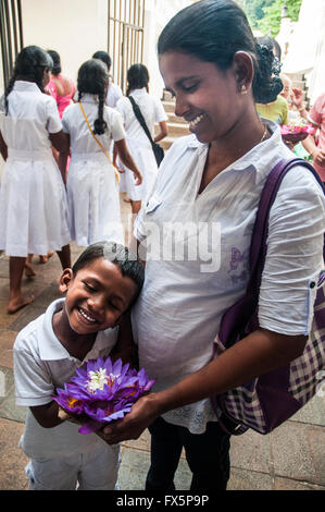 Mère et fils pèlerins visitant le Temple de la dent (Dalada Maligawa) à Kandy, Sri Lanka Banque D'Images