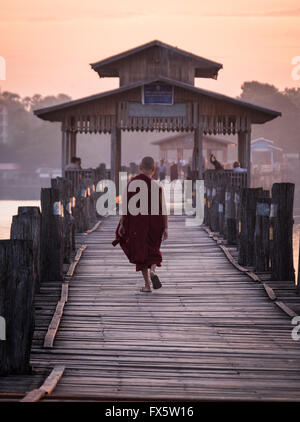 Un novice en traversant le pont de U Bein à l'aube Banque D'Images