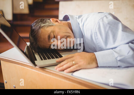 Le professeur dormir sur son ordinateur portable au bureau Banque D'Images