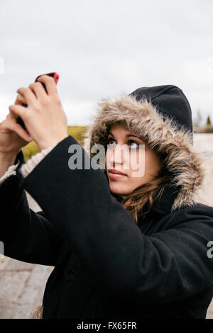 Caucasian woman en tenant l'extérieur selfies Banque D'Images
