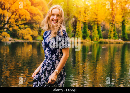 Caucasian woman smiling près de pond in park Banque D'Images