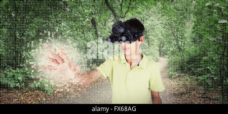 Mixed Race boy portant des lunettes de réalité virtuelle en forêt à distance Banque D'Images