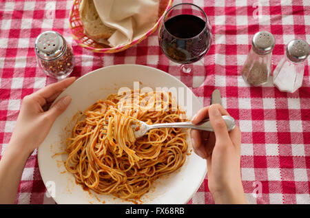 Hispanic woman eating plat de pâtes Banque D'Images
