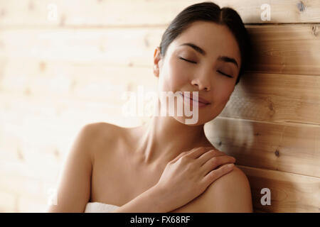 Hispanic woman relaxing in sauna Banque D'Images