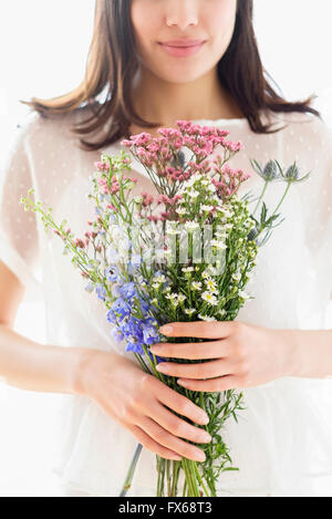 Hispanic woman holding bouquet de fleurs Banque D'Images