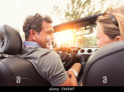 Caucasian couple driving convertible Banque D'Images