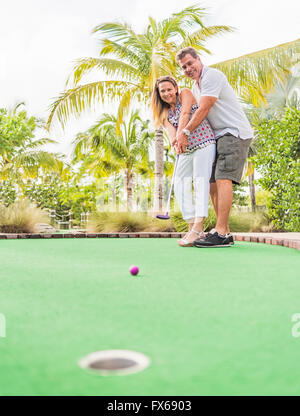 Caucasian couple playing miniature golf Banque D'Images