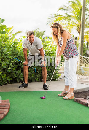 Caucasian couple playing miniature golf Banque D'Images