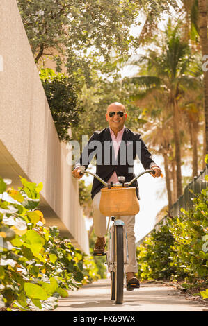 Caucasian businessman riding bicycle Banque D'Images