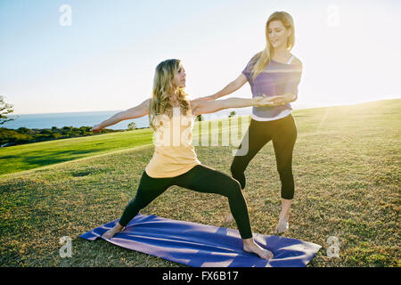 Caucasian woman practicing yoga avec formateur dans le champ Banque D'Images