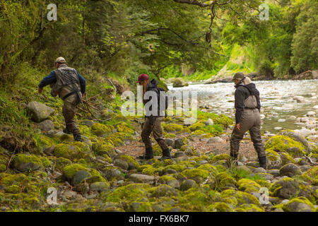 Caucasian friends walking in remote river Banque D'Images