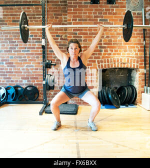 Caucasian woman lifting weights in gym Banque D'Images