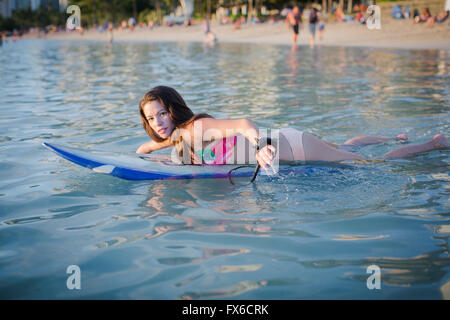 Mixed Race amputee natation with surfboard