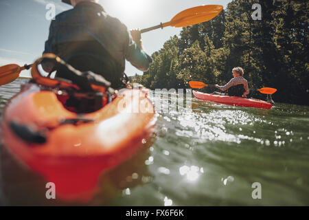 Portrait de femme mature en kayak sur le lac d'une journée ensoleillée. Couple canoë dans un lac sur journée d'été. Banque D'Images