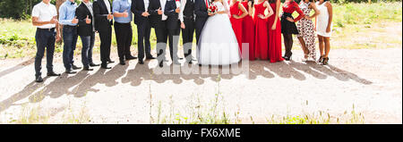 Bride and Groom standing avec des invités dans le jardin Banque D'Images