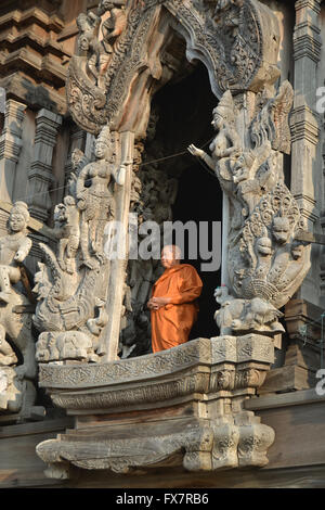 Les moines vêtus de robes orange dans un temple en bois sculpté Banque D'Images