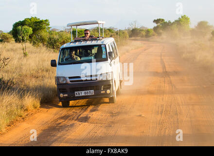 Flip Top safari Toyota van roulant les pistes en terre rouge du parc national de Tsavo dans le sud du Kenya à la recherche de la faune Banque D'Images