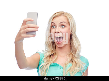 Smiling young woman with smartphone selfies Banque D'Images