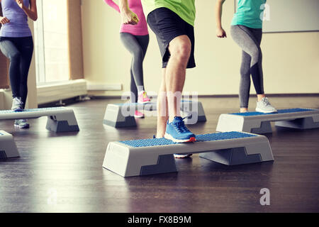 Groupe de personnes la flexion jambes sur les plates-formes étape Banque D'Images