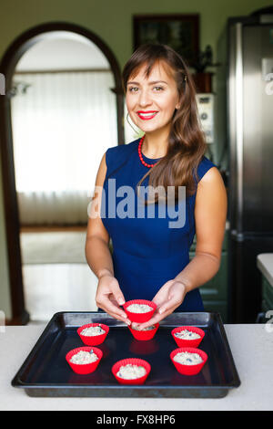 Jeune femme faisant un régime alimentaire des muffins dans la cuisine Banque D'Images