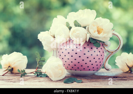 Bouquet de roses dans un plateau/bouilloire. Mariage ou anniversaire still life style rétro.. Banque D'Images