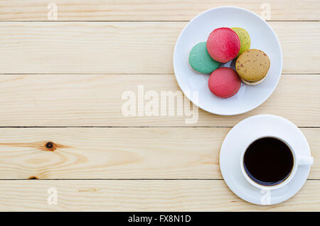 Tasse de café et macarons sur table en bois, vue du dessus Banque D'Images