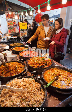 Les gens qui achètent de la nourriture à un chinese street food, Brick Lane, Spitalfields, que vous recherchiez un dimanche l'Est de Londres, UK Banque D'Images