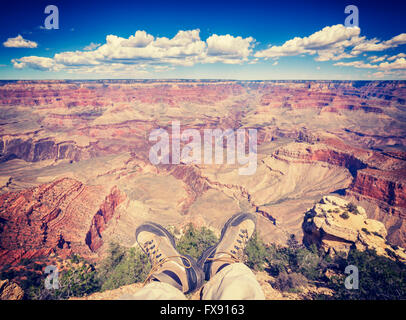 Tons Vintage jambes avec de vieilles chaussures de marche par le Grand Canyon falaise, adventure concept photo. Banque D'Images