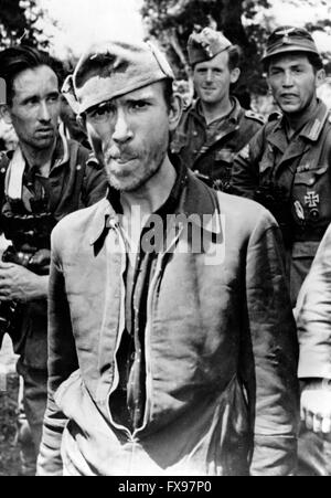 L'image de propagande nazie dépeint des soldats de la Wehrmacht allemande avec un partisan yougoslave emprisonné en Yougoslavie. La photo a été publiée en juillet 1943. Depuis l'été 1942, le nom 'partisan' a été interdit par les Allemands pour des raisons psychologiques et remplacé par le nom 'Banden' (gangs), 'Banditen' (bandits) et 'Bandenbekaempfung' (gangs de combat). Fotoarchiv für Zeitgeschichtee - PAS DE SERVICE DE VIREMENT - Banque D'Images