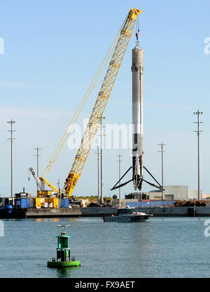 Port Canaveral, Floride, USA. 12 avril, 2016. La première étape d'une fusée SpaceX Falcon 9 est hissé par une grue à Port Canaveral, Floride après son retour au port pendant la nuit sur un drone barge. La fusée a atterri avec succès sur la barge pour la première fois le 8 avril 2016 après avoir été lancée de Cap Canaveral avec un dragon spacecraft sur une mission de ravitaillement pour la Station spatiale internationale. SpaceX espère pouvoir réutiliser la fusée dans les mois à venir. Crédit : Paul Hennessy/Alamy Live News Banque D'Images