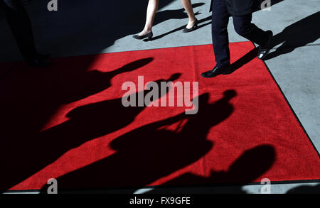 Munich, Allemagne. 13 avr, 2016. Les silhouettes de l'attente des photographes sont vus sur le tapis rouge comme le ministre bavarois de l'économie, des médias, de l'énergie et de la technologie, Ilse Aigner (CSU, L) et un compagnon de marche sur le tapis rouge lors de la visite du roi Willem-Alexander et Maxima La reine des Pays-Bas à la 'World' de BMW à Munich, Allemagne, 13 avril 2016. Le couple royal néerlandais est sur une période de deux jours en Bavière. PHOTO : PETER KNEFFEL/dpa/Alamy Live News Banque D'Images