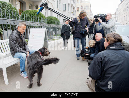 Hanovre, Allemagne. 13 avr, 2016. Rocé chien Toby part son propriétaire de l'animal sont entourés par des photographes en face d'un immeuble à appartements à Hanovre, Allemagne, 13 avril 2016. Des traces de pattes d'un chien a été trouvé sur les marches d'un immeuble à appartements à Hanovre et tribunal de district de Hanovre est maintenant en train d'examiner si les éraflures sur les étapes, à gauche par un chien, appartenait à Toby. PHOTO : JULIAN STRATENSCHULTE/dpa/Alamy Live News Banque D'Images