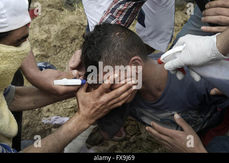 Eidonemi, Grèce. 13 avr, 2016. Grèce / Macédoine/Idomeni frontière Gevgelija 13 avril 2016:des centaines de migrants ont tenté aujourd'hui de briser la barrière qui les sépare de la Macédoine, la police a répondu par des gaz lacrymogènes, des balles en caoutchouc et des bombes sonores après les migrants ont réussi à briser la barrière. Des dizaines de blessés et intoxiqués par les gaz lacrymogènes. Credit : Danilo Balducci/ZUMA/Alamy Fil Live News Banque D'Images