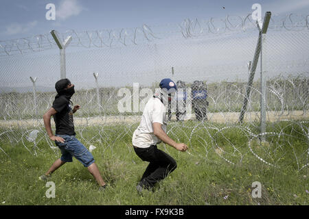 Idomeni, Grèce. 13 avr, 2016. Des centaines de migrants ont tenté de briser la barrière qui les sépare de la Macédoine, la police a répondu par des gaz lacrymogènes, des balles en caoutchouc et des bombes sonores après avoir réussi à forcer les migrants à travers la clôture. Des dizaines ont été blessées et touchés par le gaz lacrymogène. © Danilo Balducci/ZUMA/Alamy Fil Live News Banque D'Images