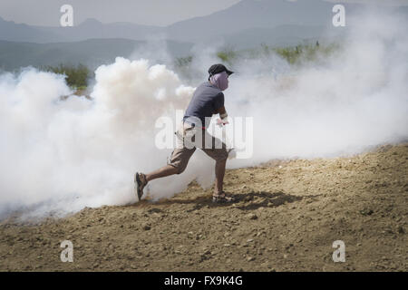 Idomeni, Grèce. 13 avr, 2016. Des centaines de migrants ont tenté de briser la barrière qui les sépare de la Macédoine, la police a répondu par des gaz lacrymogènes, des balles en caoutchouc et des bombes sonores après avoir réussi à forcer les migrants à travers la clôture. Des dizaines ont été blessées et touchés par le gaz lacrymogène. © Danilo Balducci/ZUMA/Alamy Fil Live News Banque D'Images