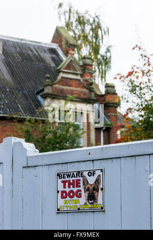 Une Attention au chien signe sur une grande porte en bois à l'extérieur d'une grande maison. Banque D'Images