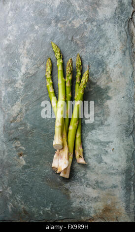 Les asperges vertes fraîches brutes sur fond ardoise gris Banque D'Images