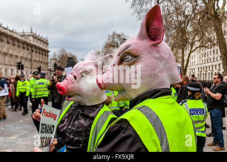 Les manifestants portant des masques de cochon appel à la démission du Premier Ministre David Cameron, London, UK Banque D'Images