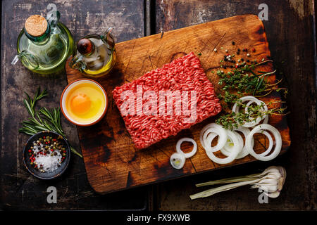 Matières viande hachée fraîche la farcissure prг©parent et condiments sur fond sombre Banque D'Images