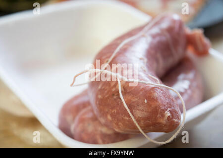 Saucisses de porc cru dans un bain à remous en polystyrène Banque D'Images