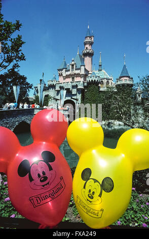 Ballons colorés avec le visage de Mickey Mouse flotter en face de Château de La Belle au bois dormant, une imposante structure de conte de fées qui est l'élément central de l'économie la plus célèbre parc à thème, Disneyland, qui a ouvert ses portes en 1955 à Anaheim, Californie, USA. Le bâtiment a été conçu d'après un vrai château de Neuschwanstein, en Allemagne, construit à la fin des années 1800 comme un palais pour le roi Louis II de Bavière. Disneyland a été la création de Walt Disney, un entrepreneur américain bien connu et cinéaste qui a créé Mickey Mouse et autres personnages emblématiques. Banque D'Images