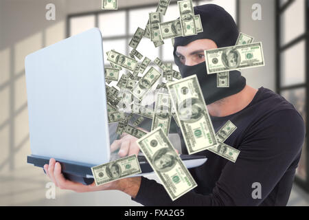 Image composite de l'accent cambrioleur avec balaclava holding laptop Banque D'Images