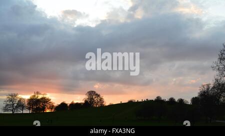 Un coucher de soleil spectaculaire, orange ciel avec nuages gris, avec les arbres et l'homme, Primrose Hill, Londres Banque D'Images