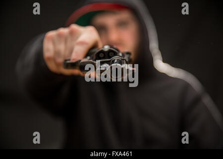 Un jeune points criminel un pistolet à l'afficheur Banque D'Images