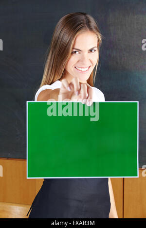 Happy smiling woman holding empty panneau vert Banque D'Images