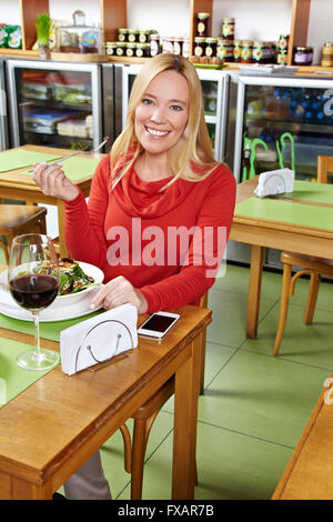 Personnes âgées smiling woman manger son déjeuner dans un restaurant. Banque D'Images