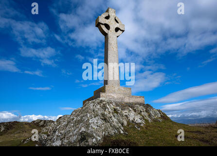 Celtic croix de pierre érigée sur une colline contre un ciel bleu. Banque D'Images