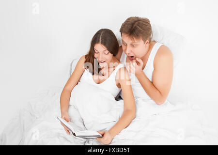 Femme enceinte et son mari reading book Banque D'Images